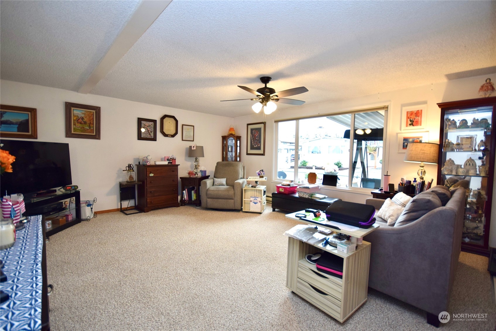 52 Juniper Mobile Estate Sequim, WA 98382 - Photo 7 of 21 a living room with furniture a fireplace and a flat screen tv
