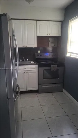 a kitchen with a sink a stove and cabinets
