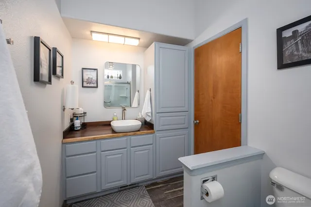 a bathroom with a granite countertop sink a mirror and a toilet