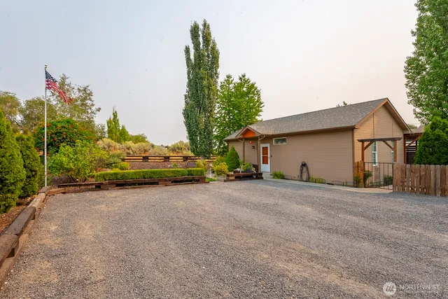 a view of a house with a backyard and trees