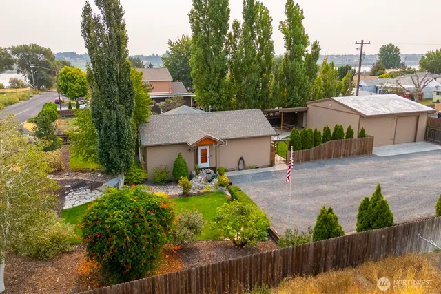 a view of a house with a big yard plants and large trees