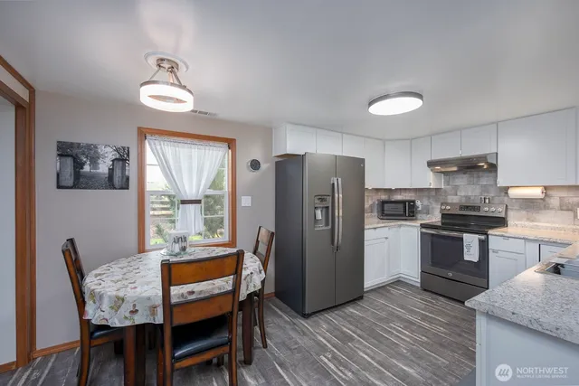 a kitchen with refrigerator cabinets dining table and chairs