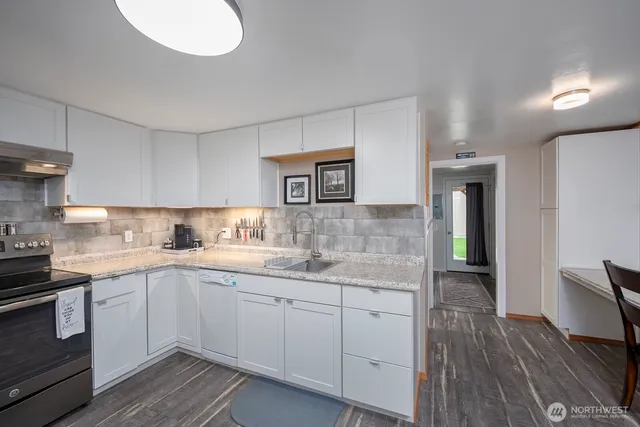 a kitchen with sink cabinets and wooden floor
