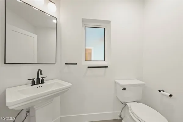 a bathroom with a toilet a sink and mirror