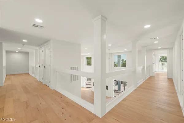 a view of a hallway with wooden floor and staircase