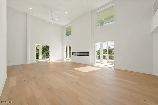 a view of an empty room with a window and a kitchen