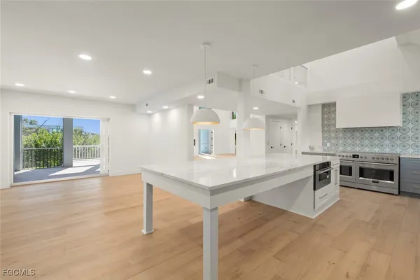a large white kitchen with a large window
