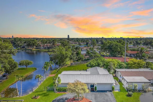 an aerial view of a house with a garden and lake view