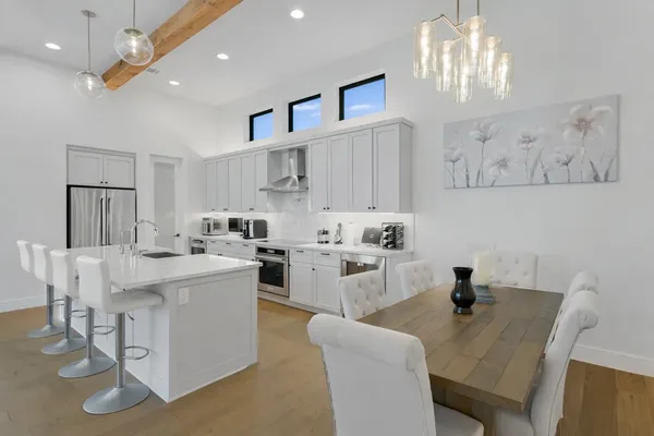 a kitchen that has a lot of cabinets in it with granite countertop chairs