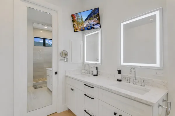 a bathroom with double vanity sink and a mirror