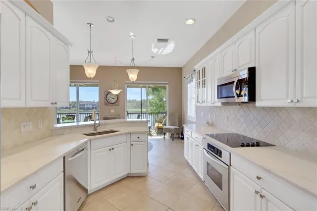 a kitchen with a sink a counter top space stainless steel appliances and cabinets
