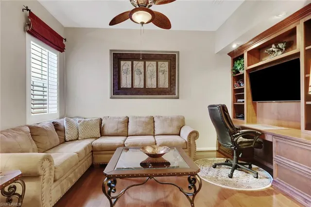 a living room with furniture flat screen tv and a window