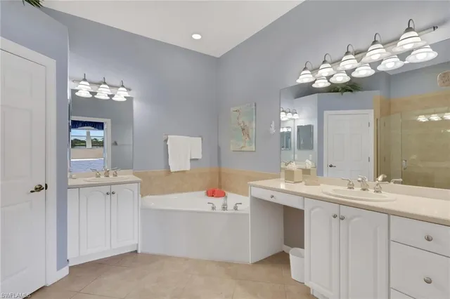 a bathroom with a tub sink and mirror