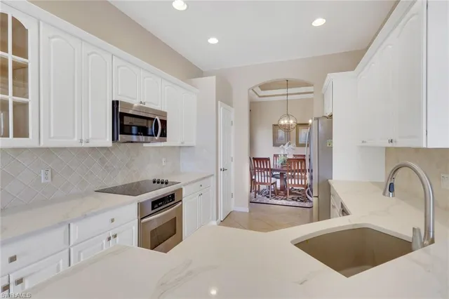 a kitchen with stainless steel appliances granite countertop a sink stove and microwave