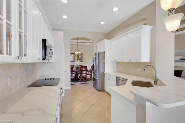 a kitchen with a sink a refrigerator and a stove top oven