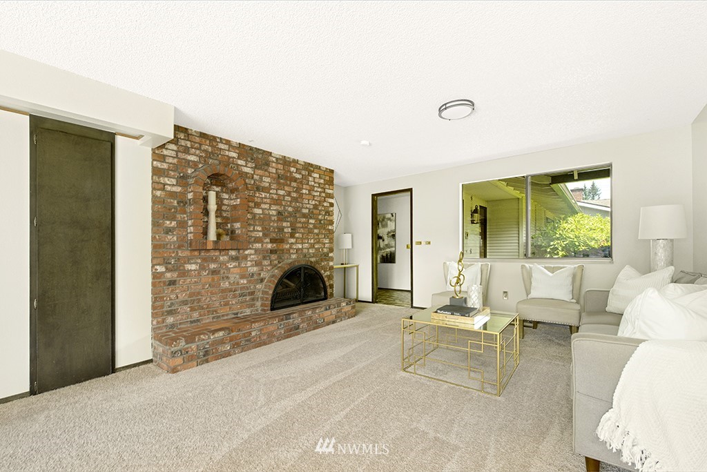 14413 157th Place Southeast Renton, WA 98059 - Photo 6 of 29 a living room with furniture a fireplace and a floor to ceiling window