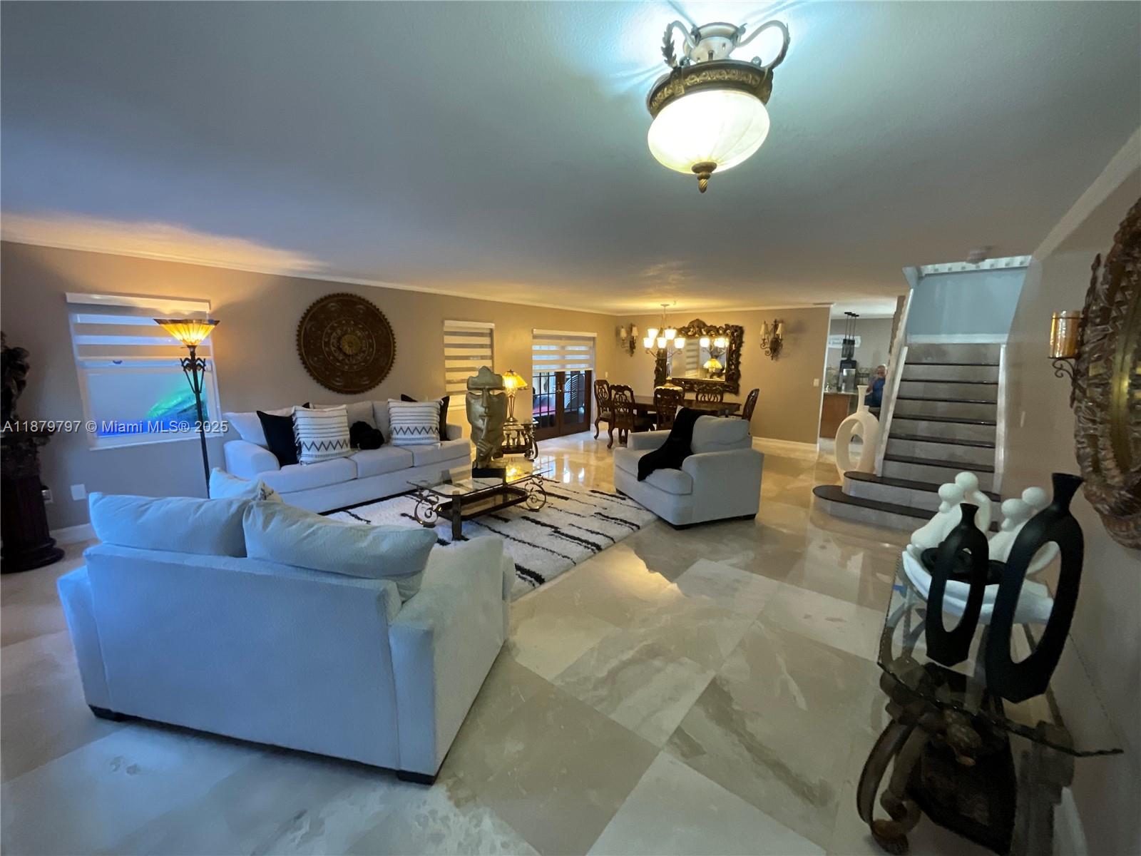 a living room with couches and kitchen view with wooden floor