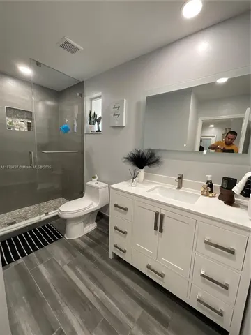 a bedroom with a bed and a flat tv screen on dresser