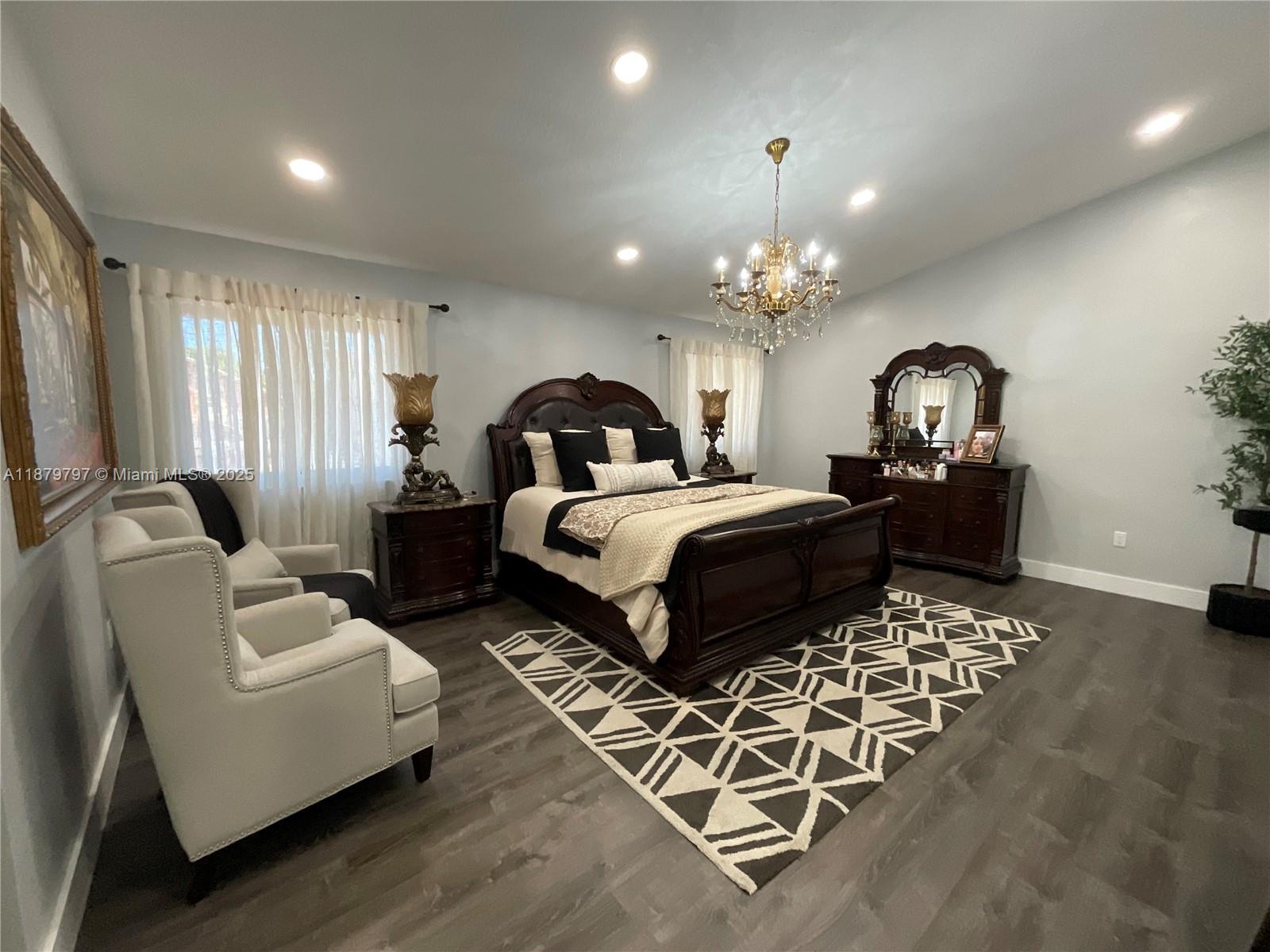 9710 Southwest 13th Street, Unit 9710 Pembroke Pines, FL 33025 - Photo 32 of 43 a bedroom with furniture and a chandelier