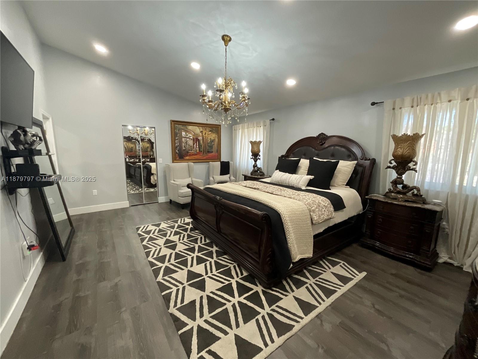 9710 Southwest 13th Street, Unit 9710 Pembroke Pines, FL 33025 - Photo 33 of 43 a bedroom with double bed and a chandelier