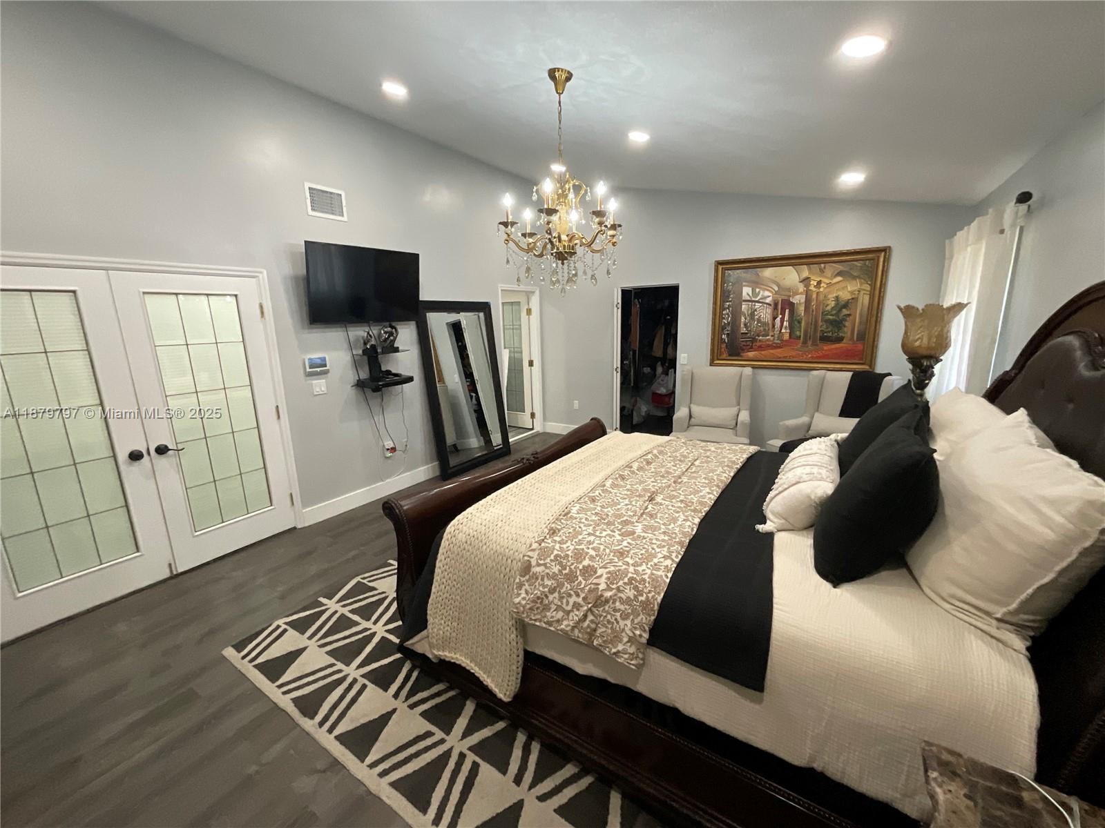 9710 Southwest 13th Street, Unit 9710 Pembroke Pines, FL 33025 - Photo 34 of 43 a bedroom with a bed and a flat screen tv