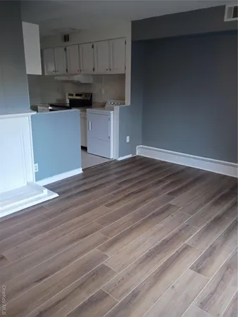 a kitchen with stainless steel appliances wooden floor and cabinets