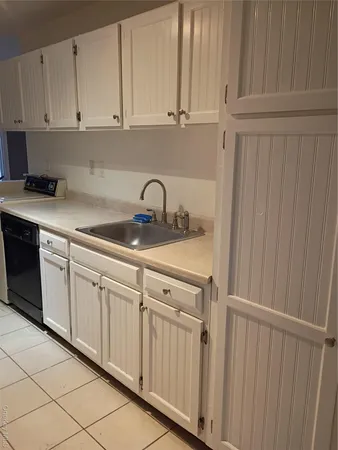 a kitchen with white cabinets and white appliances