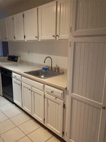 a kitchen with white cabinets and white appliances
