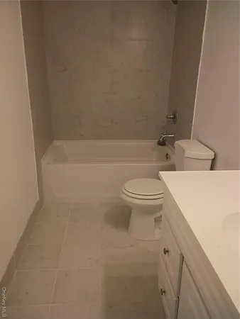 a bathroom with a granite countertop toilet a sink and bathtub