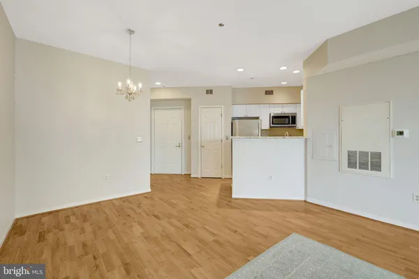 a view of empty room with kitchen and fireplace
