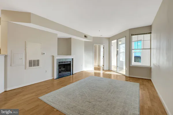 a view of a livingroom with a chandelier fan and windows