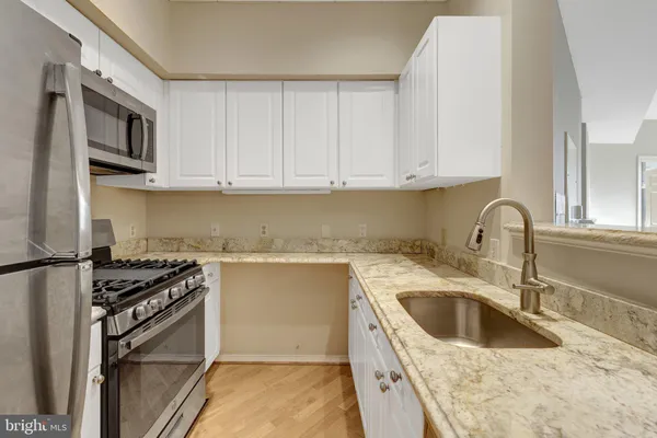 a kitchen with granite countertop a stove and a microwave