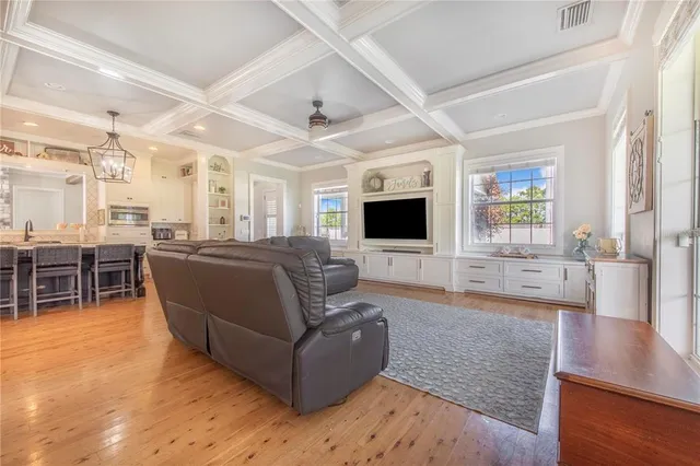 a kitchen with stainless steel appliances a refrigerator a sink a stove and white cabinets with wooden floor