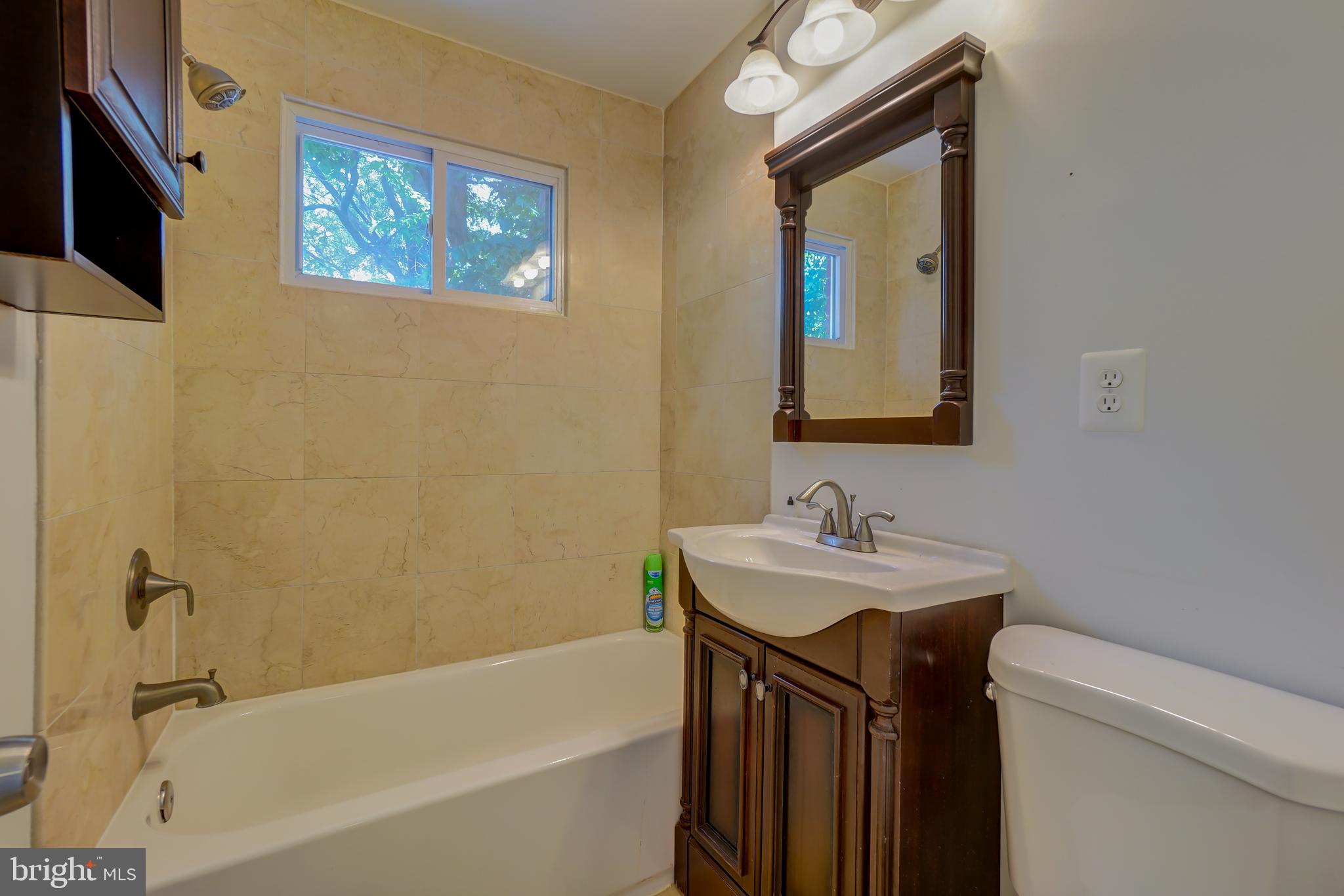 628 Four Mile Road Alexandria, VA 22305 - Photo 20 of 29 a bathroom with a sink a mirror and a bathtub