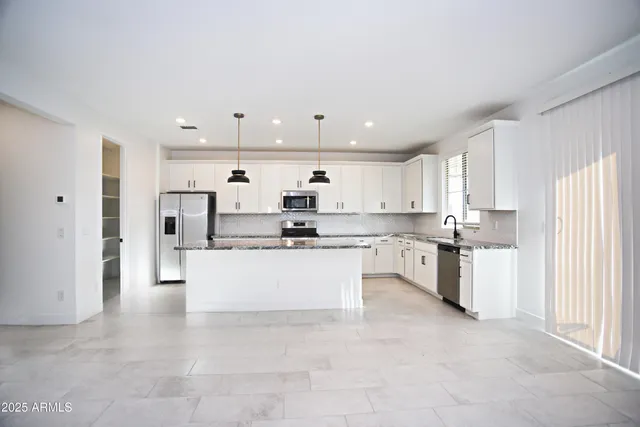 an empty room with a window and ceiling fan