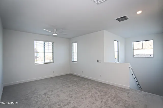 an empty room with a window and a fan