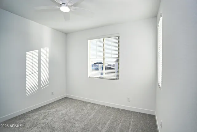 a view of a white house with a small yard and a large window