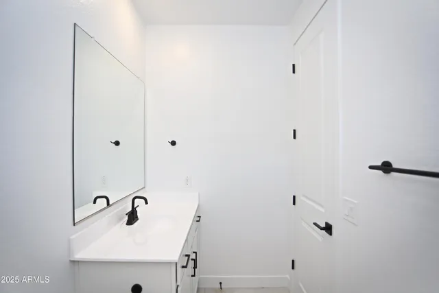 a view of a hallway with white walls and stairs
