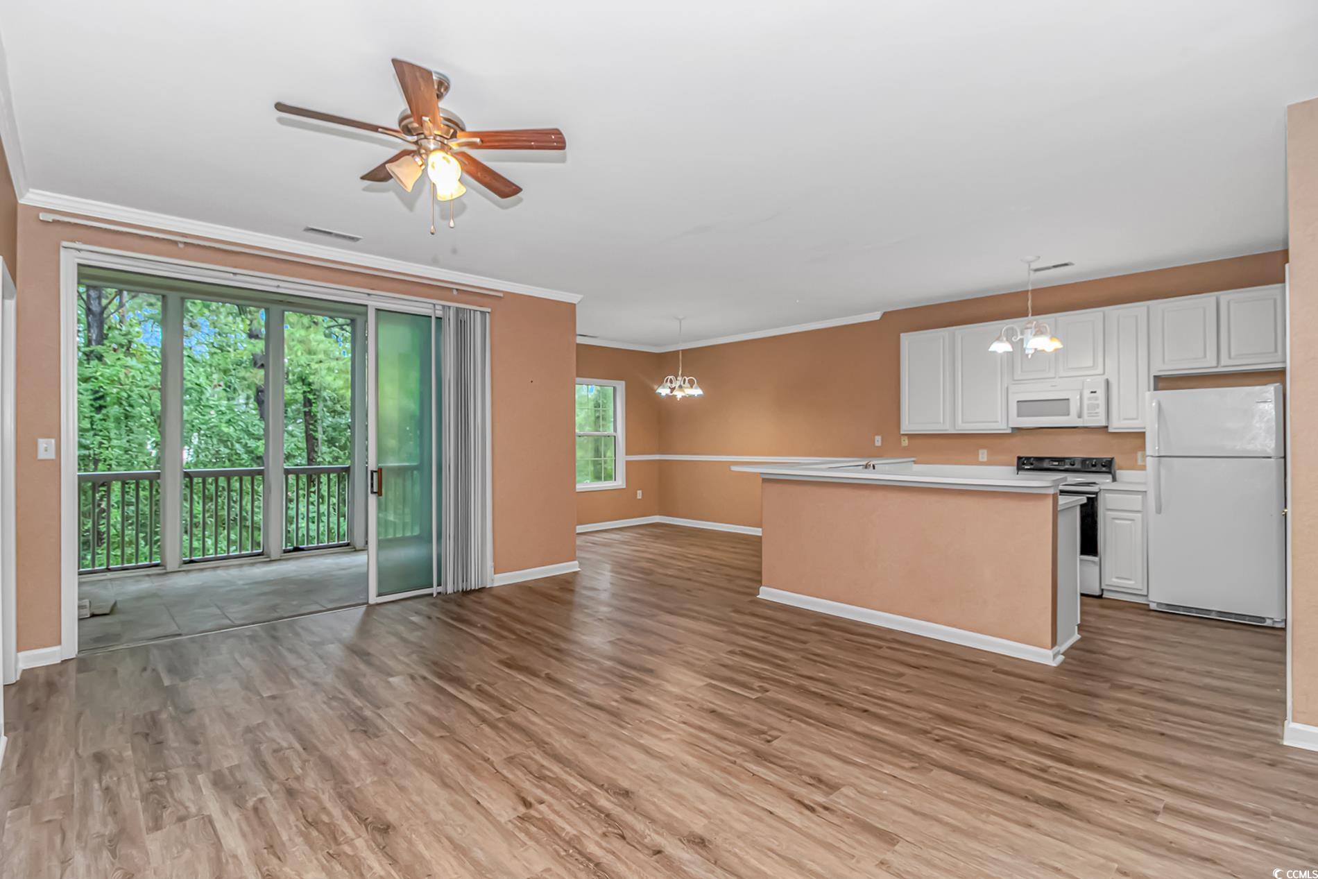 4814 Innisbrook Court, Unit 407 Myrtle Beach, SC 29579 - Photo 31 of 31 Kitchen with a chandelier, white appliances, open floor plan, white cabinetry, and ornamental molding