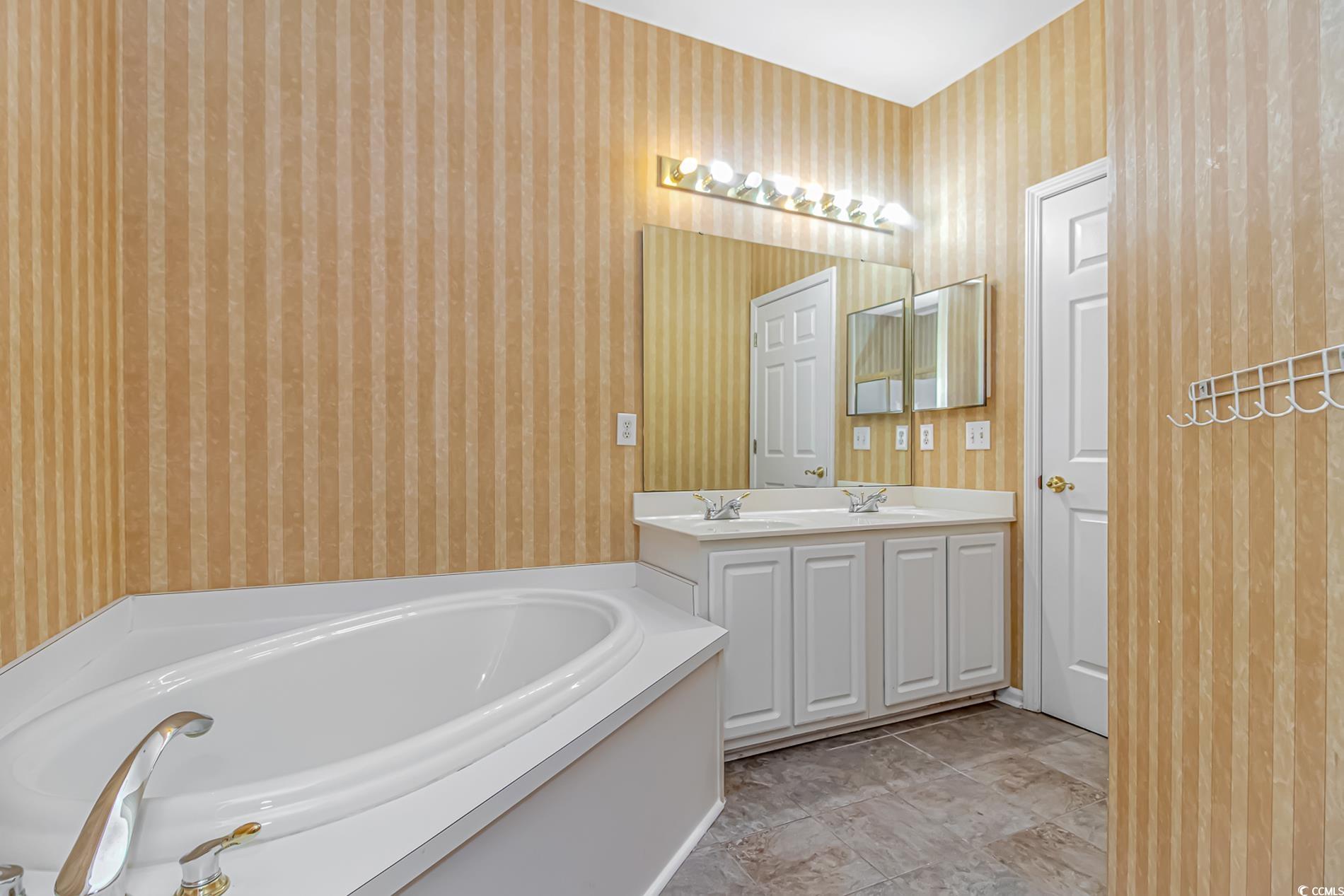 4814 Innisbrook Court, Unit 407 Myrtle Beach, SC 29579 - Photo 17 of 31 Full bathroom with a bath, wallpapered walls, and double vanity