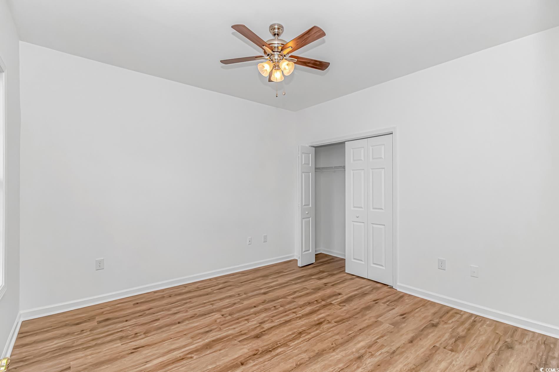 4814 Innisbrook Court, Unit 407 Myrtle Beach, SC 29579 - Photo 21 of 31 Unfurnished bedroom featuring light wood finished floors, a closet, and a ceiling fan