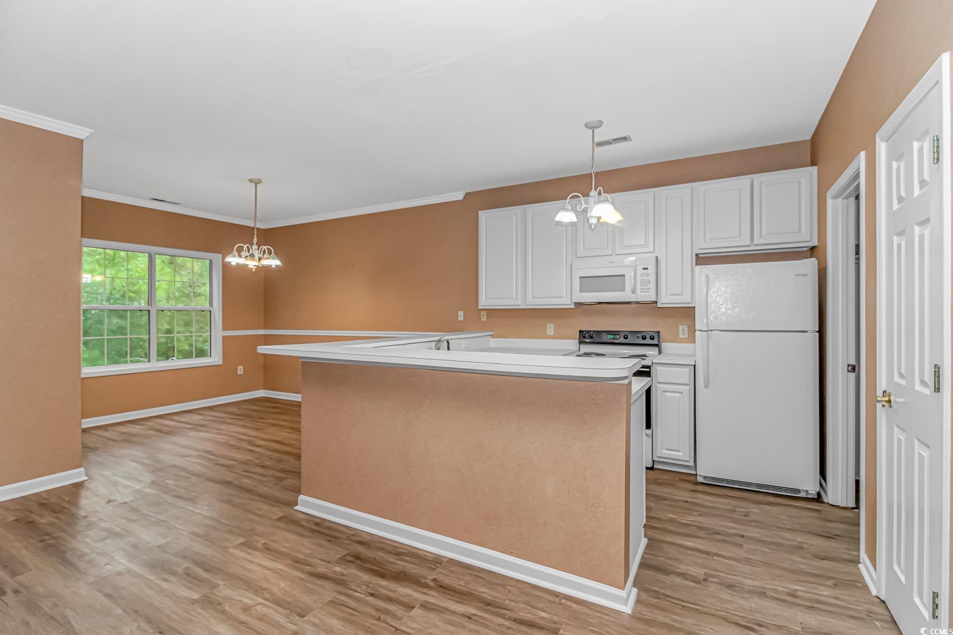 4814 Innisbrook Court, Unit 407 Myrtle Beach, SC 29579 - Photo 6 of 31 Kitchen with a chandelier, light countertops, white appliances, and white cabinets