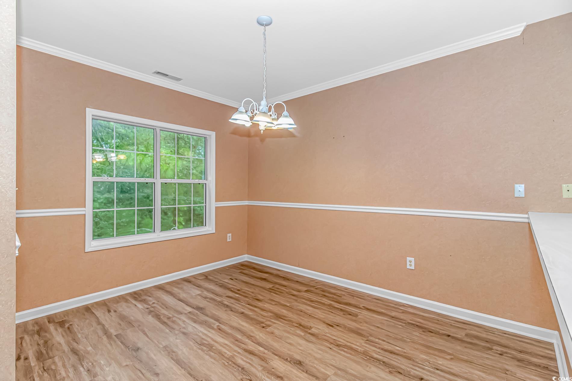 4814 Innisbrook Court, Unit 407 Myrtle Beach, SC 29579 - Photo 7 of 31 Unfurnished dining area with light wood-type flooring, a chandelier, and ornamental molding