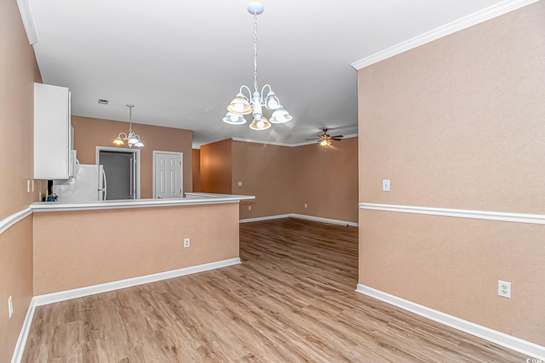 4814 Innisbrook Court, Unit 407 Myrtle Beach, SC 29579 - Photo 8 of 31 Kitchen featuring a chandelier, light countertops, decorative light fixtures, white cabinetry, and light wood finished floors