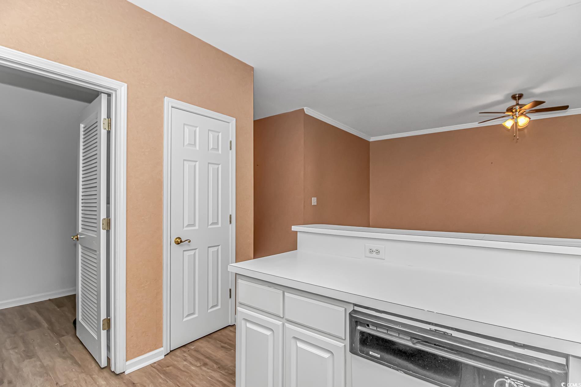 4814 Innisbrook Court, Unit 407 Myrtle Beach, SC 29579 - Photo 10 of 31 Kitchen with white cabinetry, dishwasher, light countertops, light wood finished floors, and ceiling fan