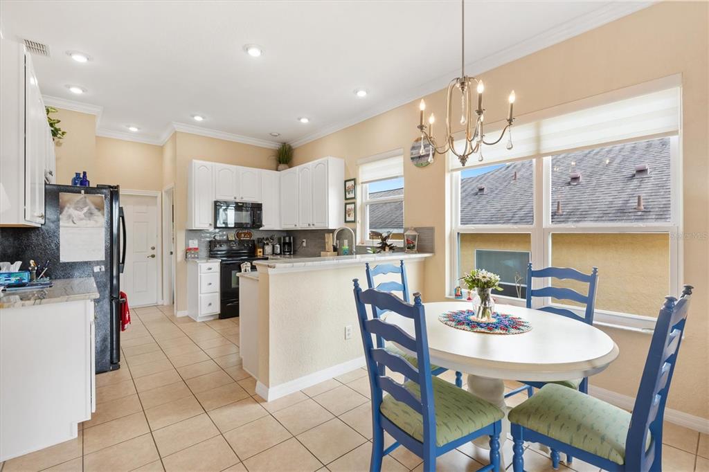 17031 Southeast 115th Terrace Road Summerfield, FL 34491 - Photo 13 of 54 a kitchen with stainless steel appliances kitchen island granite countertop a sink and cabinets
