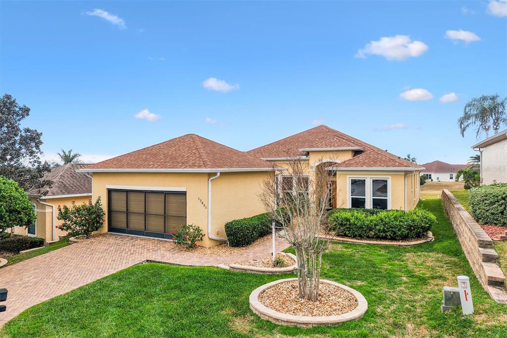 17031 Southeast 115th Terrace Road Summerfield, FL 34491 - Photo 3 of 54 a front view of a house with a yard and garage