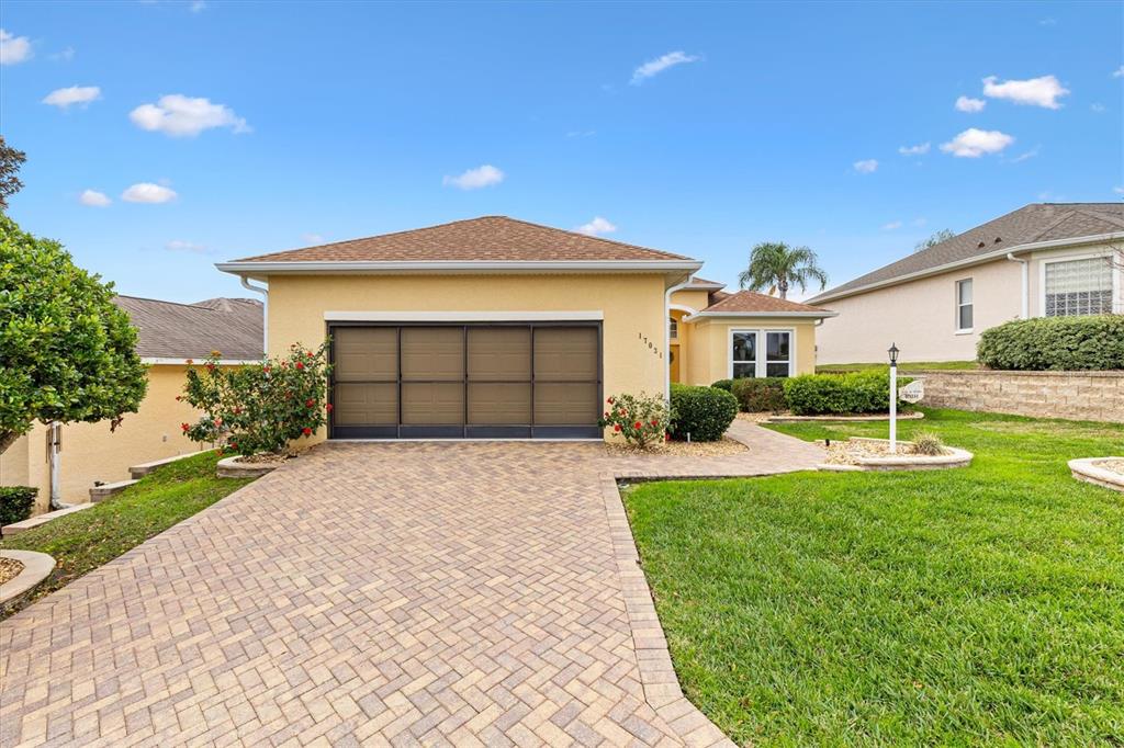 17031 Southeast 115th Terrace Road Summerfield, FL 34491 - Photo 4 of 54 a front view of a house with a yard and garage