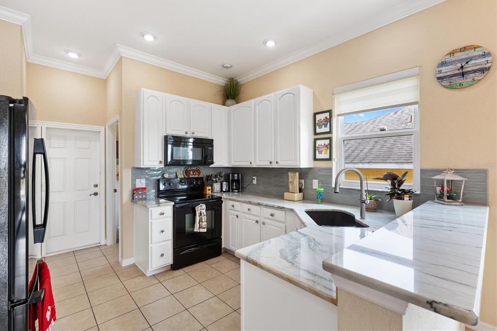 17031 Southeast 115th Terrace Road Summerfield, FL 34491 - Photo 10 of 54 a kitchen with stainless steel appliances granite countertop a refrigerator and a stove top oven