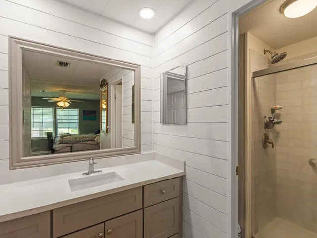 a bathroom with a shower sink and mirror